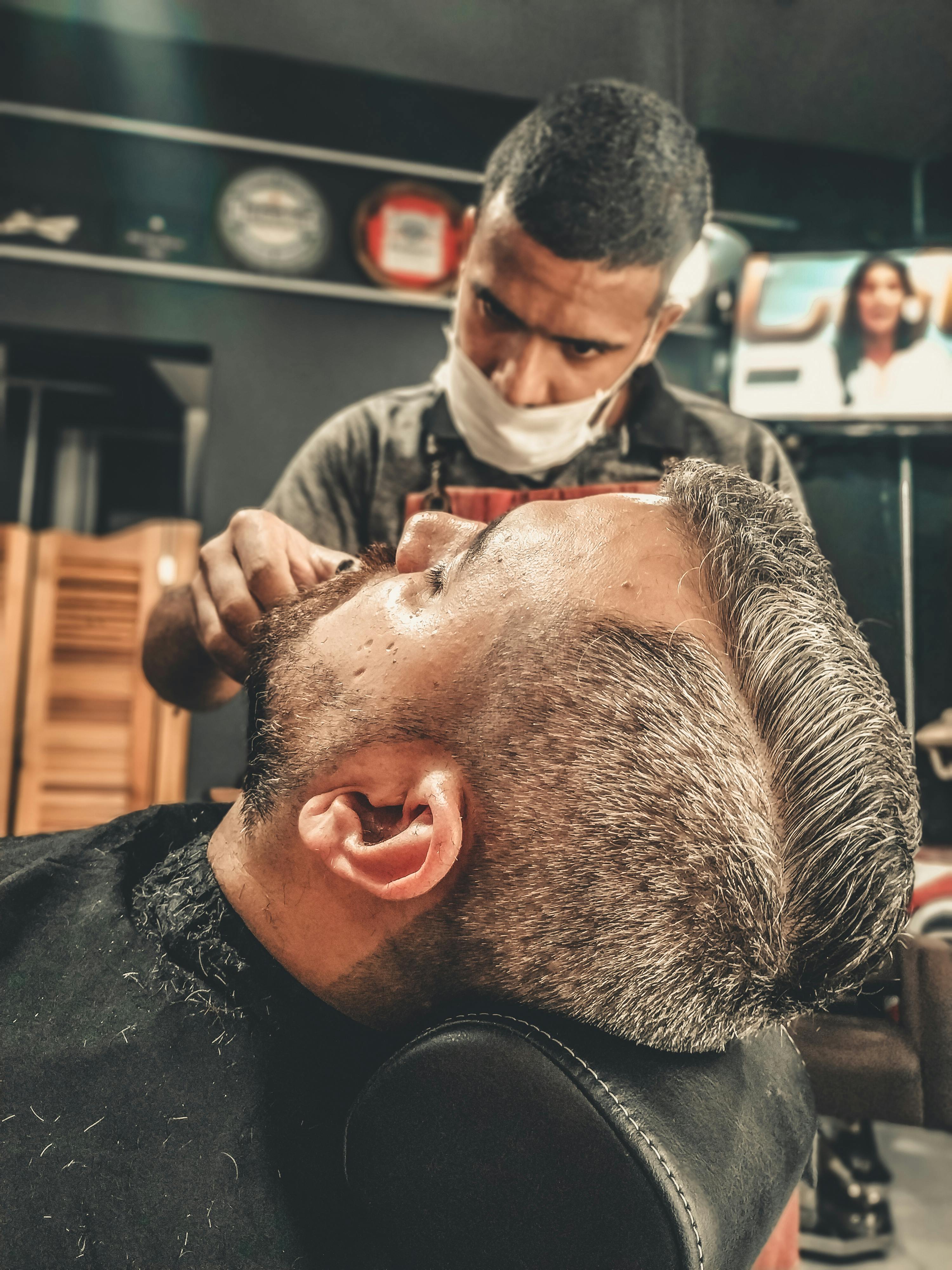 Barber cutting a clients hair using clippers in the GoodFellas barber shop